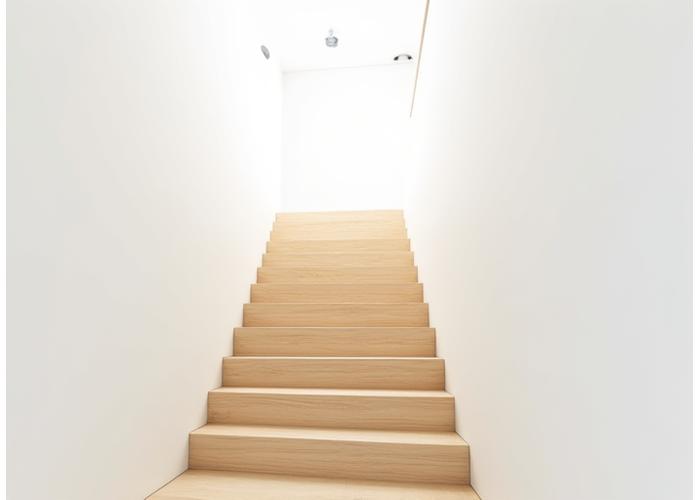 Minimalist wooden staircase with hidden supports, clean lines, and an open riser design in a bright, airy modern home